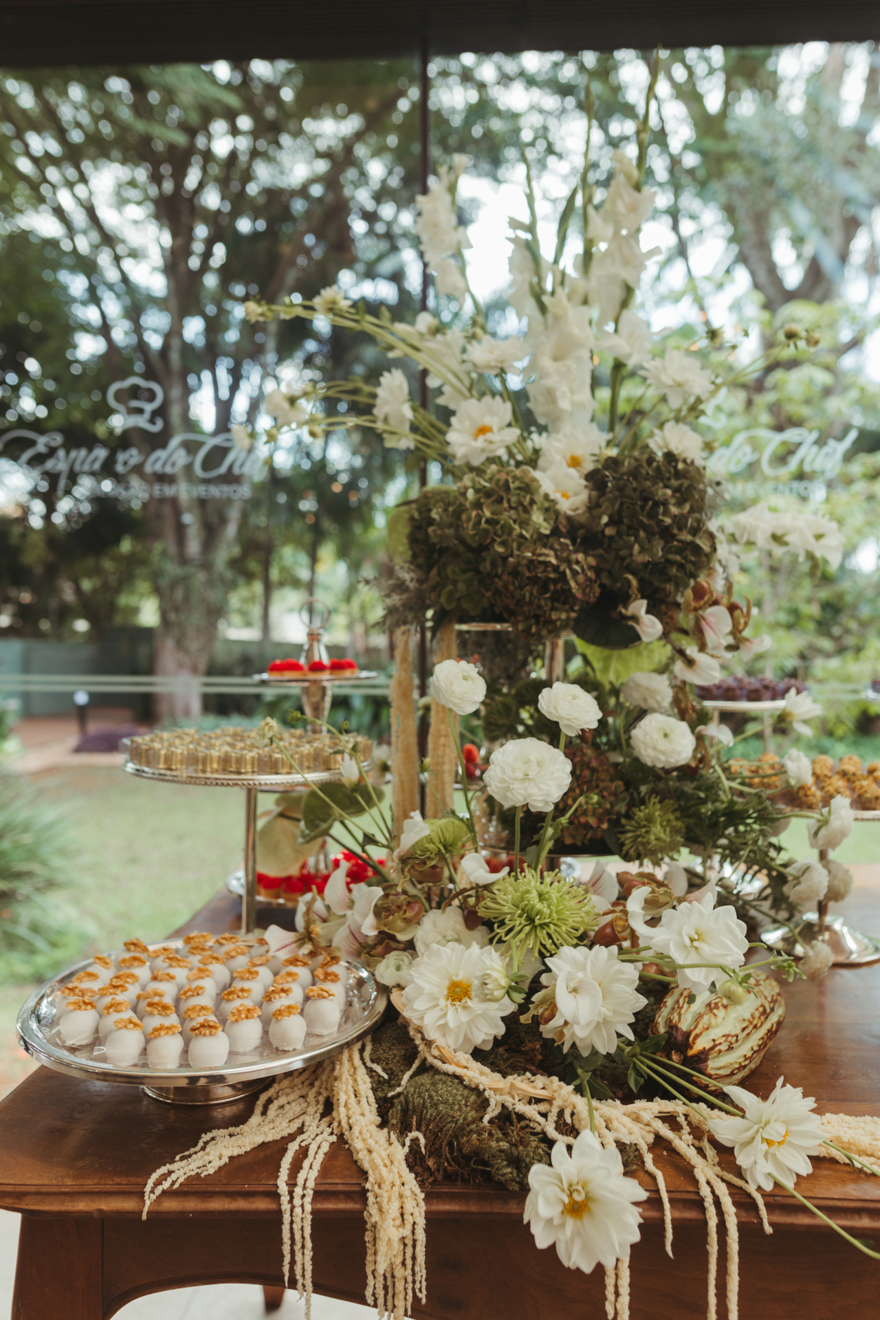 Mesa de doces com composição botânica — dálias, gladíolos e amarantos