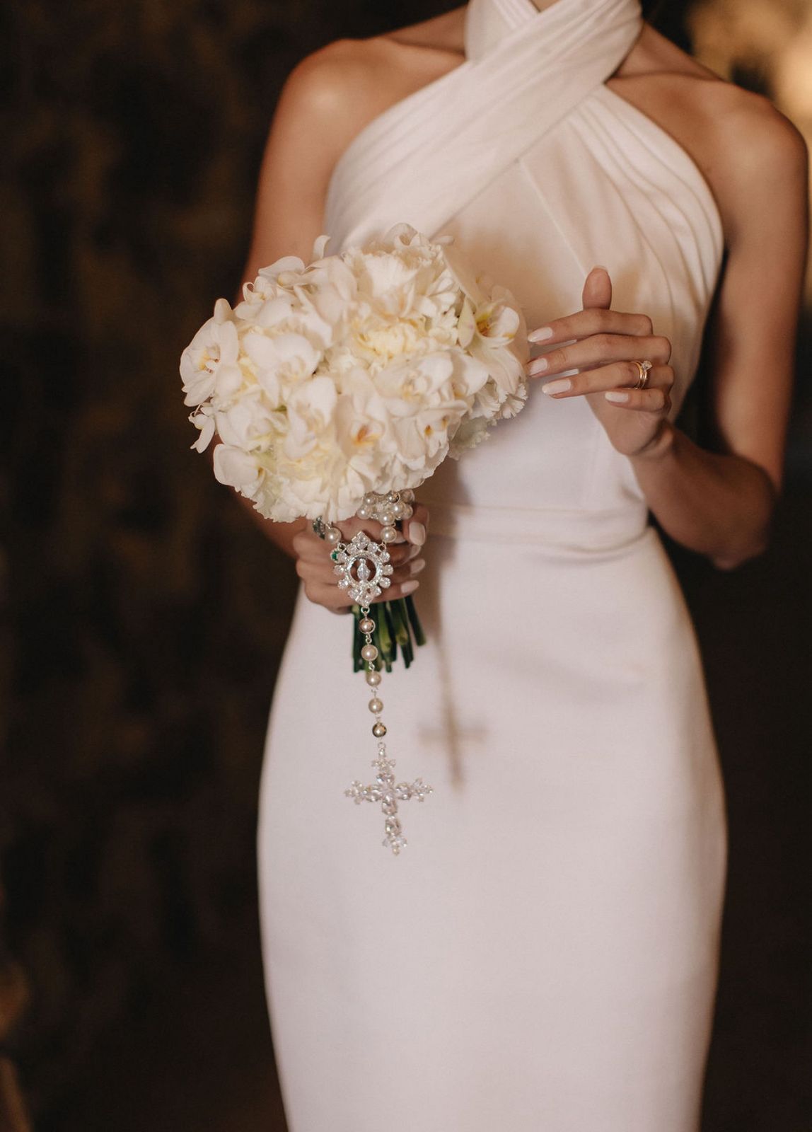 Noiva com bouquet branco de orquídeas e terço de pérolas